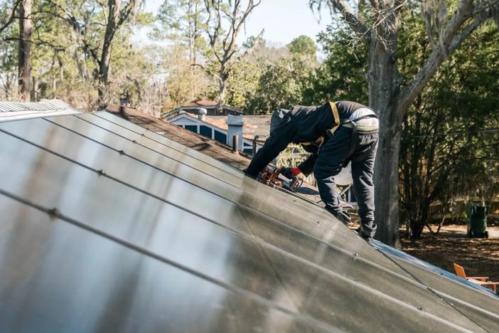 A worker installs solar panels on a roof, Feb. 6, 2024, Garden City. Credit: Justin Taylor/The Current