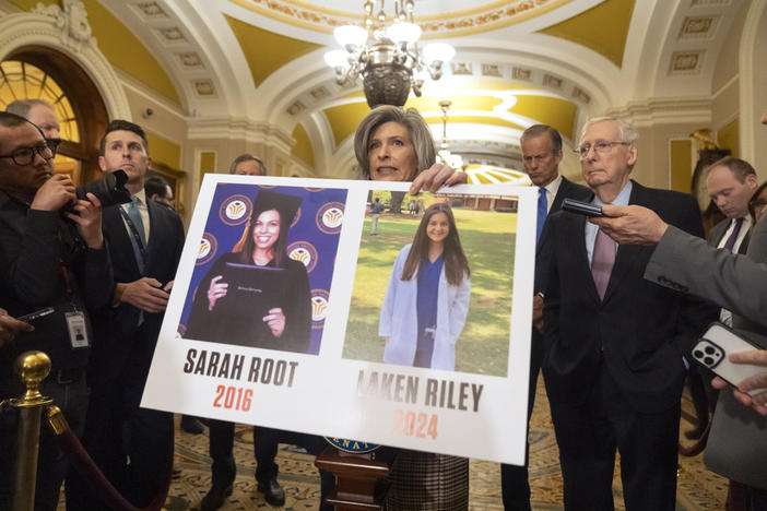 Sen. Joni Ernst, R-Iowa, holds a poster with photos of murder victims Sarah Root and Laken Riley as she speaks on Capitol Hill, Feb. 27, 2024, in Washington.