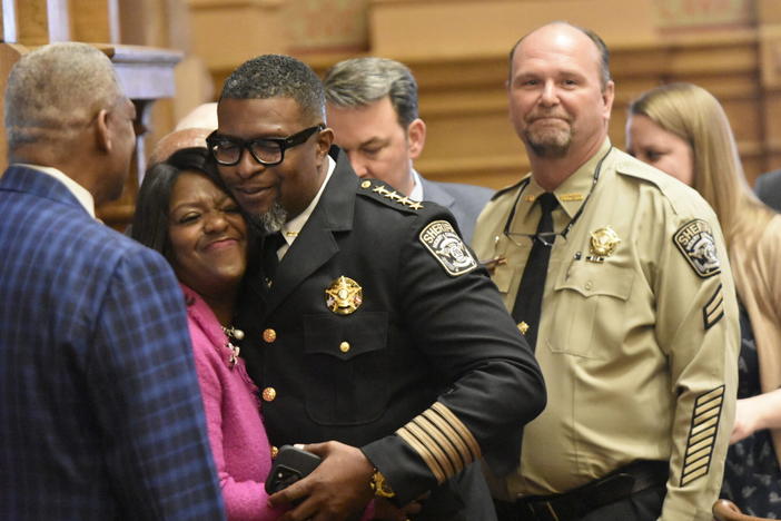 Henry County deputy Daniel D. Podsiadly pictured to the right of Democratic Senator Tonya Anderson and Henry County Sheriff Reginald Scandrett