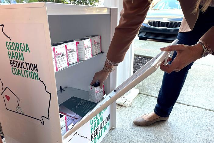 A person grabbing a box of Narcan from a free dispensary