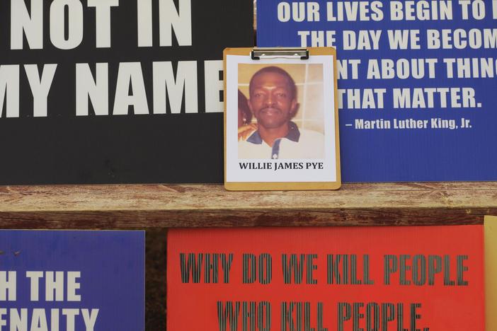 A photo of Willie Pye among protester placards. 