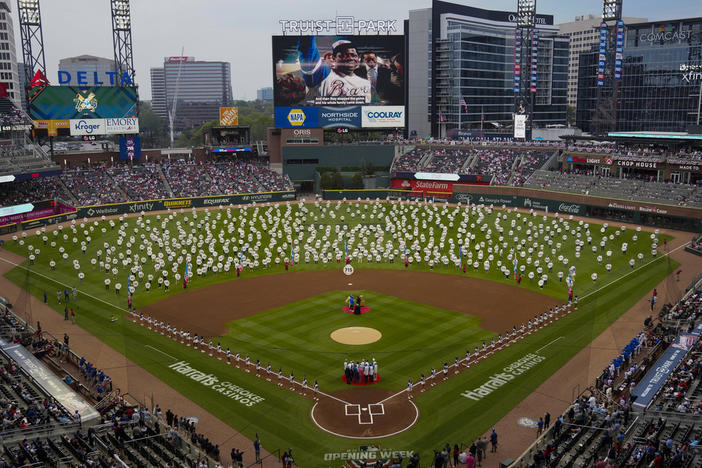 In honor of the 50th anniversary of Hank Aaron breaking Babe Ruth's home run record 715 fans stand on the field to each holding a sign to commemorate an Aaron home run before a baseball game between New York Mets and Atlanta Braves Monday, April 8, 2024, in Atlanta. Aaron passed Ruth on April 8, 1974. 