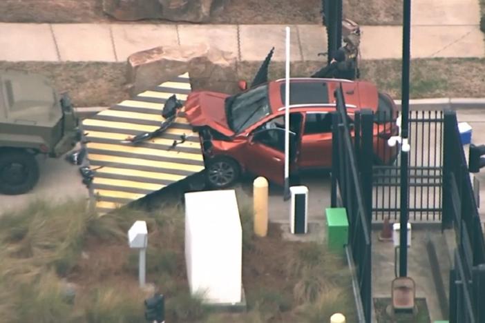In an image taken from aerial video shows a red vehicle stopped by a barrier at the front gate of the Federal Bureau of Investigation Atlanta division, Monday, April 1, 2024, in Chamblee, Ga. The FBI says a driver rammed a vehicle into the front gate of its Atlanta office, but his motives were not immediately known.