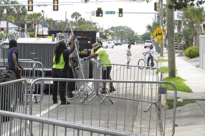 A worker places a section of metal barricade along a main road on Tybee Island, Ga., on Tuesday, April 16, 2024, a few days ahead of the weekend beach party known as Orange Crush. Black college students started the spring bash at Georgia's largest public beach more than 30 years ago. Tybee Island officials are blocking roads and parking spaces and brining in about 100 extra police officers for the party this weekend, saying record crowds last year proved unruly and dangerous.