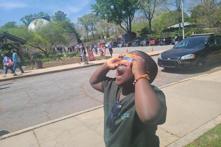 Sean Atitsogbe also known as Sean the Science Kid looks at the sun with his eclipse viewers at Fernbank Science Center's Solar Eclipse Fest.