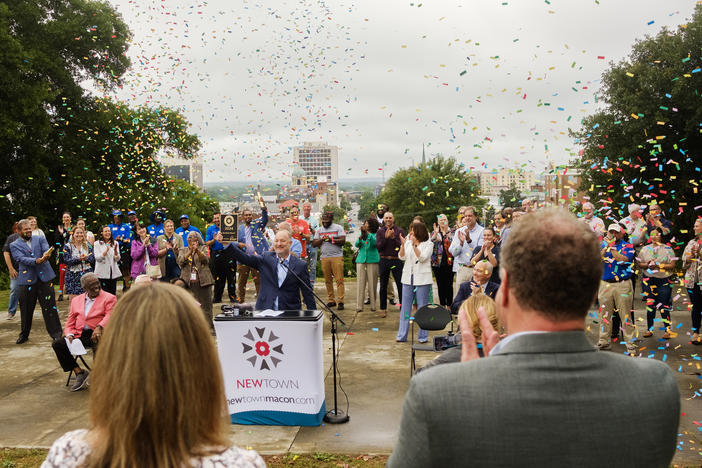 Macon-Bibb County Mayor Lester Miller hoists the city's Main Street America award at a press eventon Coleman Hill, overlooking downtown, Friday. 