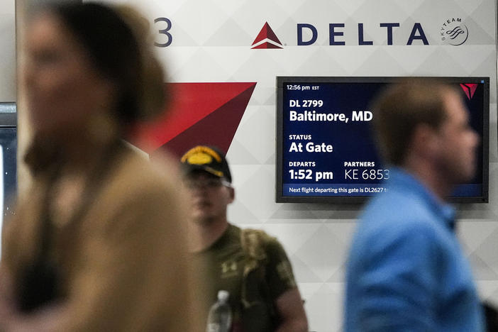 Travelers move through the terminal near a Delta Airlines desk at Hartsfield-Jackson Atlanta International Airport, Saturday, Jan. 27, 2024, in Atlanta. 