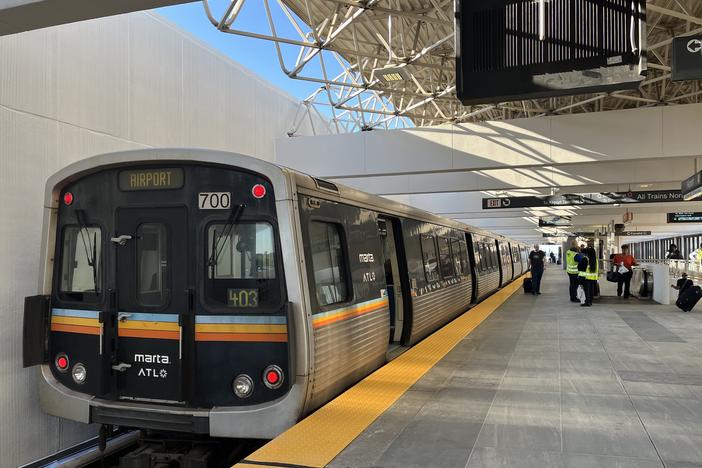 MARTA train stopped at the aiport station. A yellow tactile line can be seen on the edge of the platform and new gray tiling.