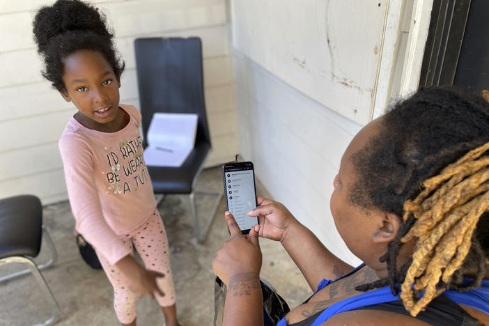 Tameka and her 8-year-old-daughter hang out outside of their apartment in Atlanta Oct. 2, 2023. Four months after The Associated Press wrote about this Atlanta family struggling to enroll in school, all of the children — in a complete turnaround — returned to class last month.