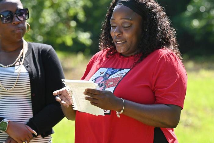 Future homeowner LaQuanda Ferguson (right) reads remarks next to Macon Area Habitat for Humanity board president Andrea Cooke during the Lynmore Estates ground blessing on Tuesday, May 28, 2024, in Macon, Georgia. Macon Area Habitat for Humanity held the ground blessing at a plot of land off of Dorothy Avenue where three future homes will be built.