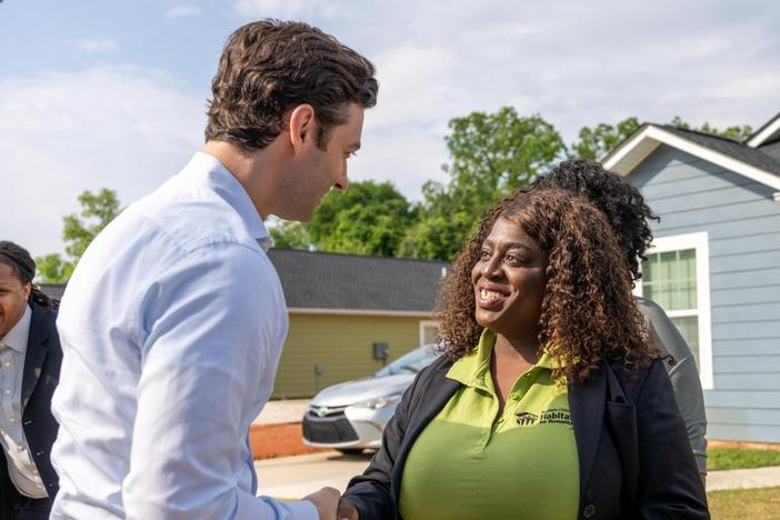 Sen. Jon Ossoff shaking hands with a Habitat for Humanity worker during a visit of a Clayton County neighboorhood.