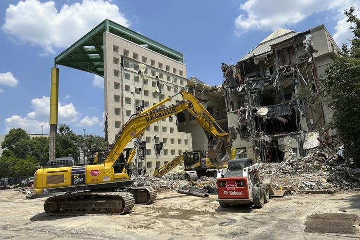 Workers knock down a former Coca-Cola Co. museum in downtown Atlanta on Friday, May 14, 2024. The World of Coca-Cola museum moved to a new site in downtown Atlanta in 2006 and Georgia state government is demolishing the vacant structure to turn it into a parking lot. (AP Photo/Jeff Amy)