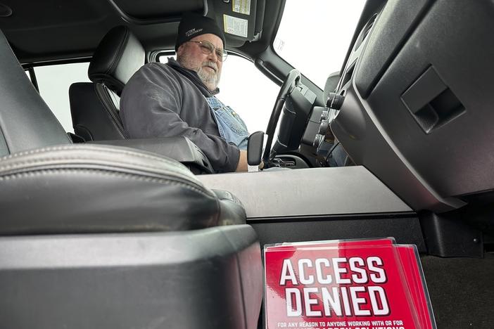 Dan McLean looks down at a sign that reads "Access denied for any reason to anyone working with or for Summit Carbon Solutions," in his truck on Wednesday, March 6, 2024, on his farm near Menoken, N.D. Summit Carbon Solutions has proposed a multistate carbon dioxide pipeline that would bury CO2 deep underground in North Dakota. The project has drawn opposition from many Midwestern landowners. 