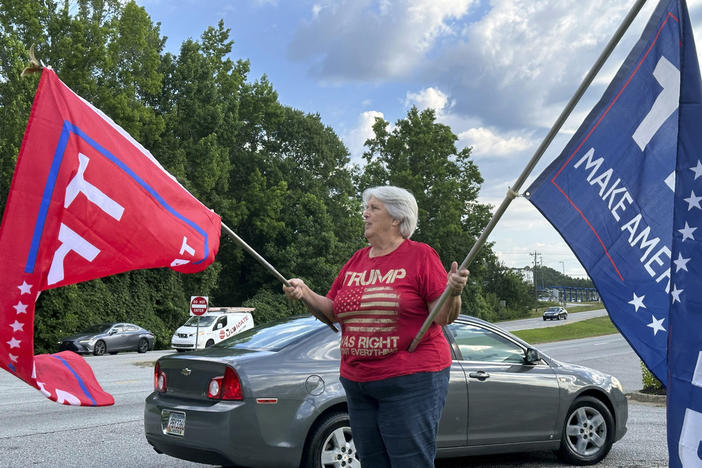 Suzanne Brown waves flags for Donald Trump before a ceremony to open his first Georgia campaign office, Thursday, June 13, 2024, in Fayetteville, Ga. Democratic President Joe Biden and former Republican President Donald Trump are working to win over Georgia voters ahead of the pair's first 2024 debate scheduled for Thursday, June 27, in Atlanta.