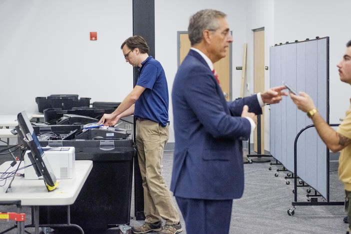 Georgia Secretary of State's Office technician Chris Bellew runs a test on Bibb County elections systems while Secretary of State Brad Raffensperger talks to a reporter Tuesday. 