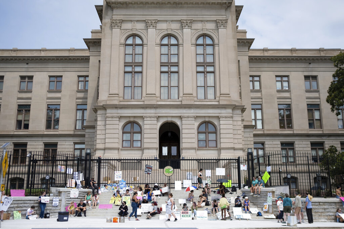 A small group gathers at the steps of the Georgia State Capitol protesting the overturning of Roe v. Wade on Sunday, June 26, 2022.