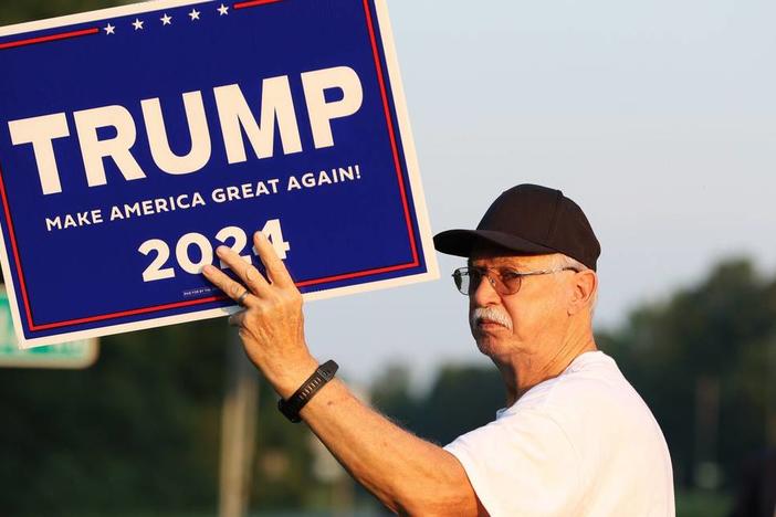 Aubrey Clark stands with a Trump 2024 sign on the side of Eisenhower Parkway on Monday, July 15, 2024, in Lizella, Georgia. A half dozen supporters, including members of the Bibb County Republican Party, gathered to show their support for former president Trump two days after an attempted assassination attempt on him in Pennsylvania. Katie Tucker/The Telegraph 