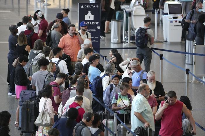 Passengers wait in line for assistance at the Delta Terminal, Friday, July 19, 2024, at Logan International Airport in Boston. 
