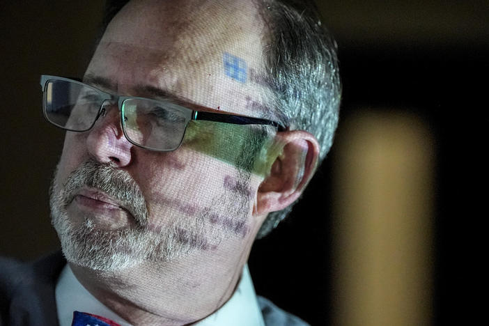 Douglas G. Frank speaks to a group of people about the Georgia election process as data is projected onto his body, Sunday, March 24, 2024, in Rome, Ga. Frank is among those urging people to file voter challenges using a software tool called EagleAI to get potentially ineligible voters removed from the registration rolls. 
