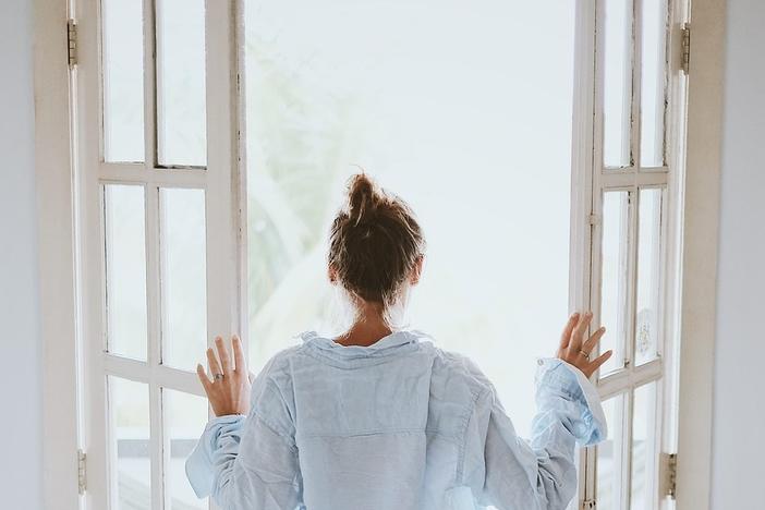 A woman opens a set of double doors 
