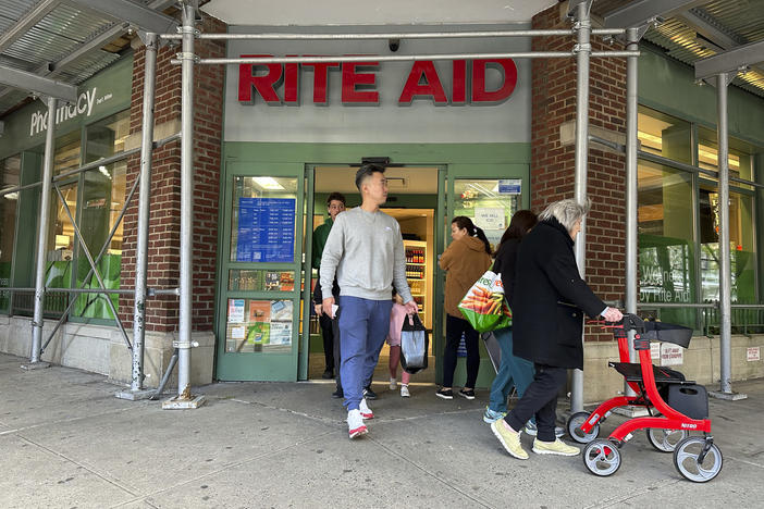 People walk out of a Rite Aid pharmacy