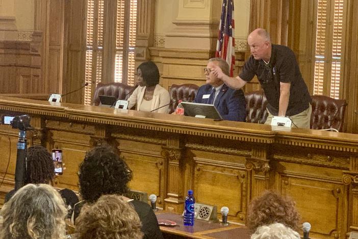  Protesters lodged accusations of open meetings violations at three conservative State Election Board members on July 12. Board member Rick Jeffares, right, responds by threatening to remove people for being disruptive while Janelle King (left) looks on. Stanley Dunlap/Georgia Recorder