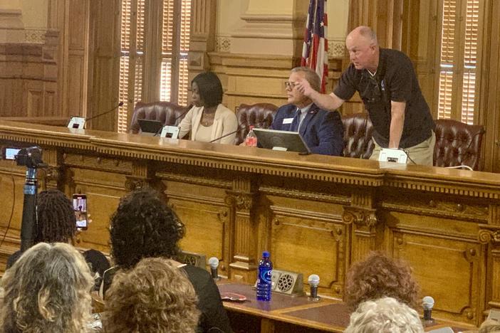  Protesters lodged accusations of open meetings violations at three conservative State Election Board members on July 12. Board member Rick Jeffares, right, responds by threatening to remove people for being disruptive while Janelle King (left) looks on. Stanley Dunlap/Georgia Recorder 
