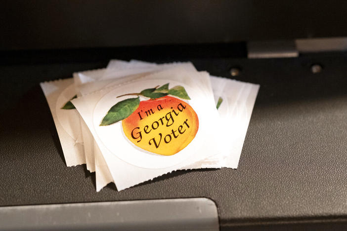 A stack of stickers sits atop the ballot scanner during the mid-term election Tuesday, Nov. 8, 2022 at Lawrenceville Road United Methodist Church in Tucker, Ga. 