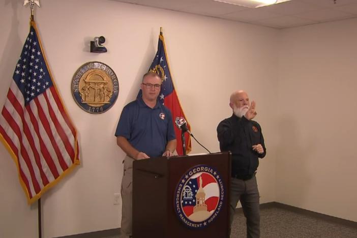 GEMA Director James C. Stallings is shown speaking behind a podium.
