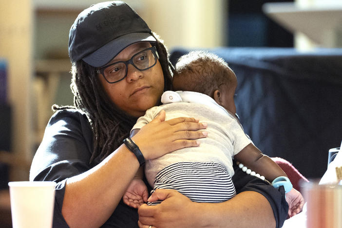 Georgia State Sen. Kim Jackson holds her son as she takes part in a reproductive health town hall meeting at Neighborhood Church Thursday, Aug. 29, 2024, in Atlanta. 
