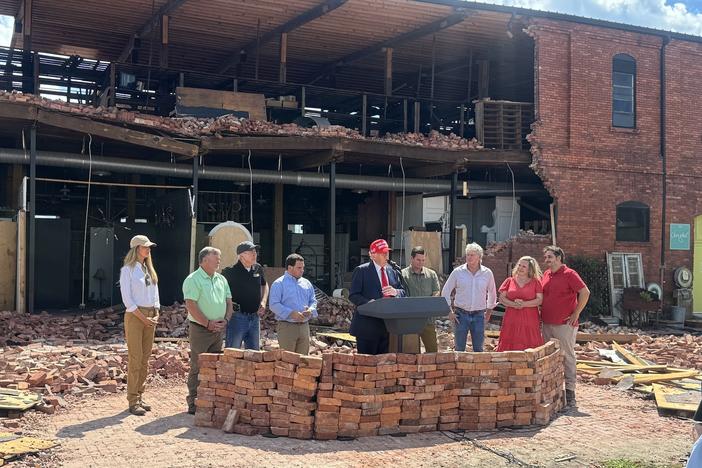 On September 30, 2024, former president Donald Trump speaks to the media in Valdosta, Ga., surrounded by local officials including Mayor Scott James Matheson (third from left) and supporters including former U.S. Senator Kelly Loeffler (far left).
