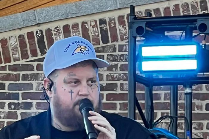 Jelly Roll wears a hat emblazoned with the Apalachee Wildcat mascot and the phrase "Love will prevail" at Jug Tavern Park on Oct. 26, 2024.
