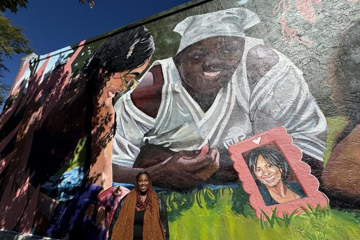 Danae Antoine, who is an Atlanta-based artist, poses for a photo they designed and painted memorializing two Georgia women who died trying to have an abortion. Jill Nolin/Georgia Recorder