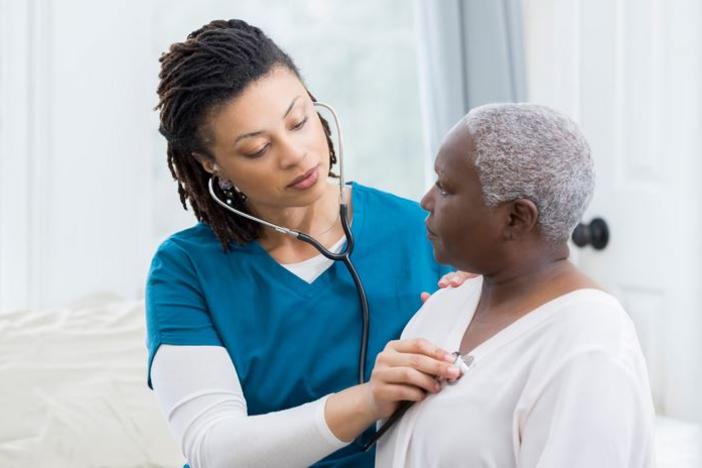 a health care provider listens to a patient's lung