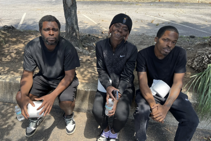 Three residents of Haven Hotel in Stone Mountain, Georgia, hold rolls of toilet paper given to them by community volunteers. The hotel charges residents $1 per roll, they say. 
