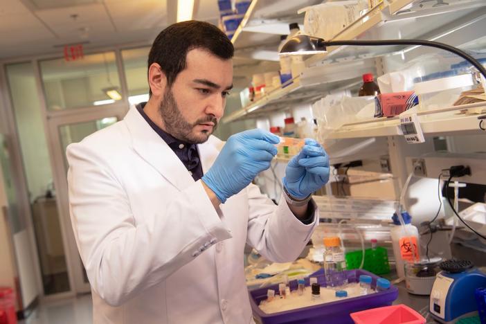 Eliver Ghosn, a researcher at the Emory Vaccine Center, holds up a test tube. Ghosn's lab published a study that examined how an antibody is linked to Covid-19 severity. (Courtesy of Emory University) 