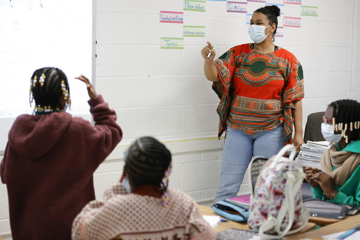 Tashiya Umoja M'kanga, of Atlanta, right, instructs students during a math lesson at the Kilombo Academic and Cultural Institute, March 28, 2023, in Decatur, Ga. 