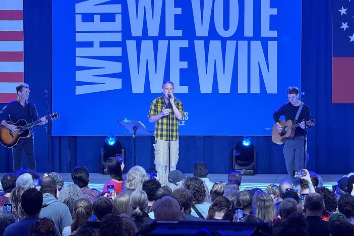 Michael Stipe (center) performs with David Barbe (left) and Andy LeMaster perform at a rally for U.S. vice presidential candidate, Governor Time Walz of Minnesota, at the Cobb Galleria in Atlanta on Nov. 3, 2024.