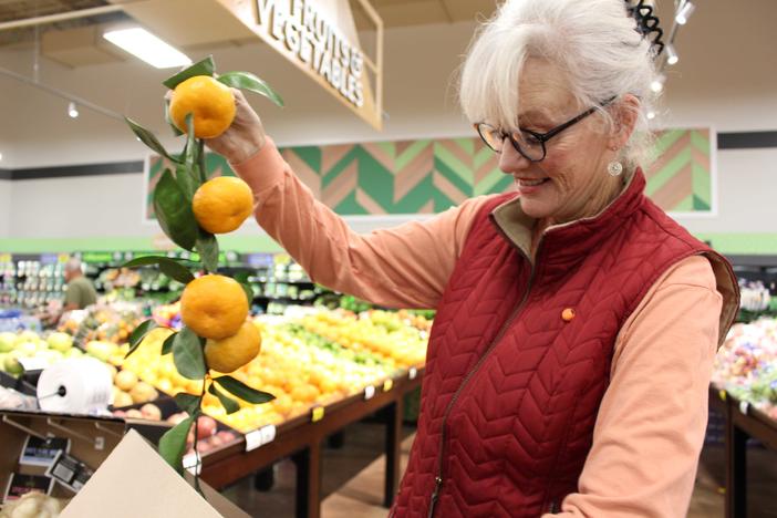 Lindy Savelle holds citrus fruit from her farm in a Kroger in Houston County, Georgia.