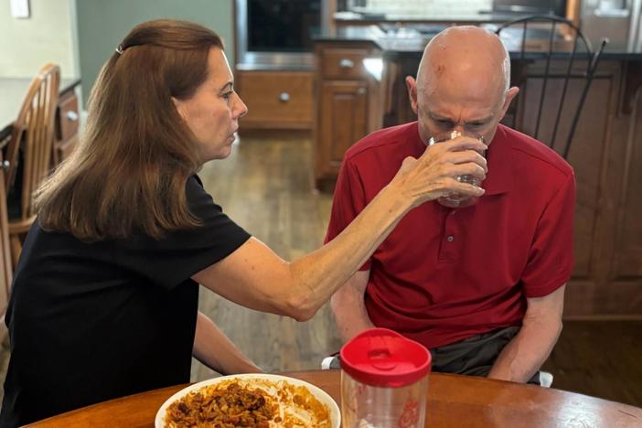 Nancy Treaster helps her husband, Kim Treaster, eat lunch.
