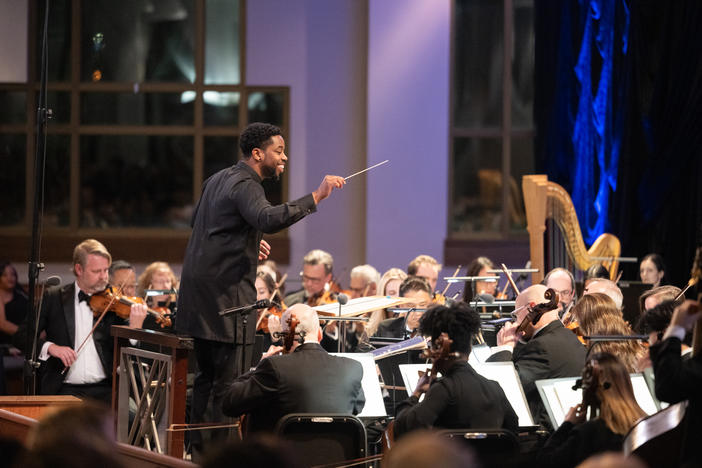 A conductor leading a symphony of musicians