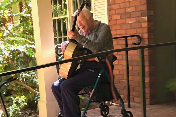 Former President Jimmy Carter plays his custom made Kostal guitar outside his home in Plains, Ga.