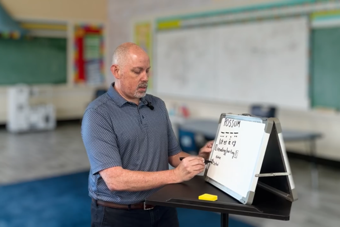 man writing on white board