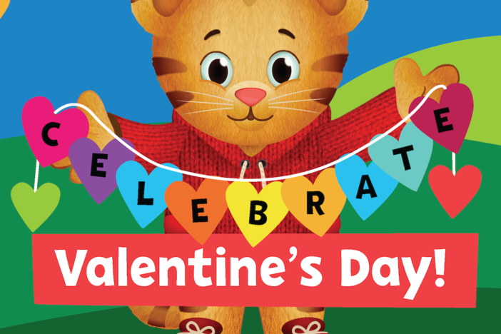 Daniel Tiger holds up a paper heart string that says "Celebrate Valentine's Day!"