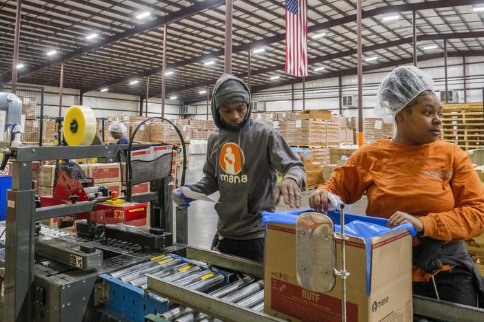 Jeremy Robinson (center) and Aliyah Hill perform last checks on packets of Mana Nutrition emergency food supplements for children before packaging them in the nonprofit’s factory in Fitzgerald, Ga. “We save lives,” Robinson said of his part of the work that has saved millions of children globally. 