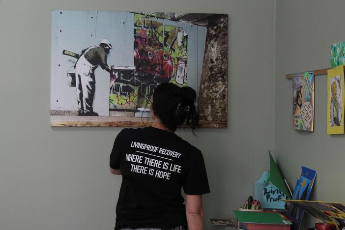 Brittney Galvanauskas looks at a piece of art on the wall at Living Proof Recovery in Rome, Georgia.