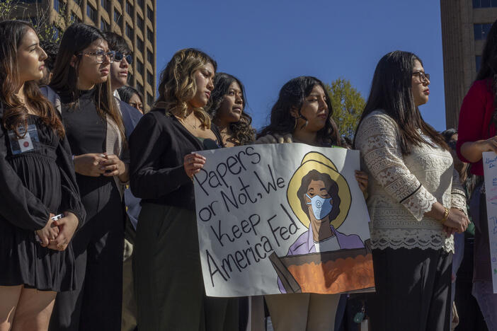 Students are shown holding a sign that says "Papers or not, we keep America fed."