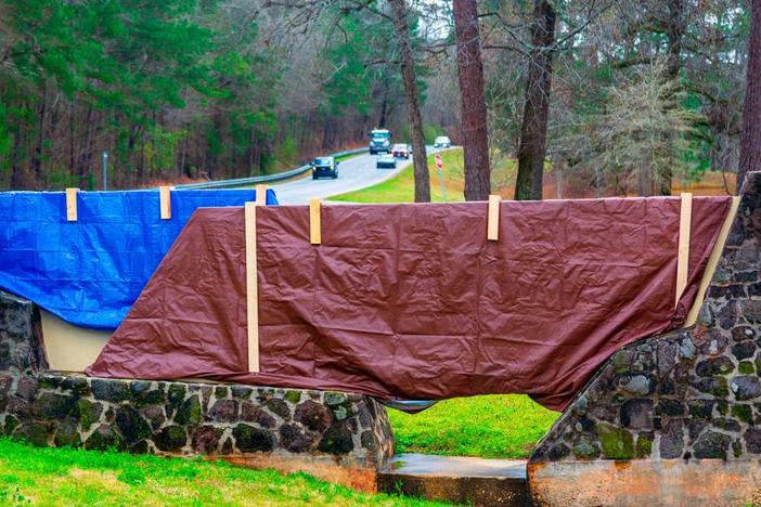 The stone gate entrance sign that welcomed people to Fort Moore is covered with tarps March 5, 2025, now that the U.S. Army post next to Columbus has been renamed back to Fort Benning. This entrance is on Ft. Benning Road. 