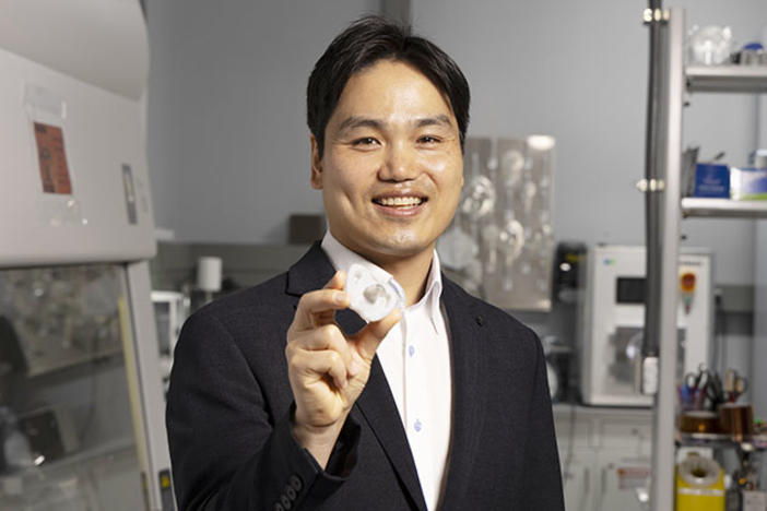 Hong Yeo holds a pacifier that can monitor electrolyte levels via saliva