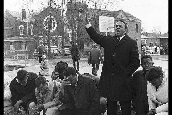 Caption: Andrew Young (right, standing) leads a prayer with Amelia Boynton, the Rev. Hosea Williams, John Lewis, and Bob Mants before the first march to Montgomery on March 7, 1965.  Credit: Spider Martin/Briscoe Center for American History